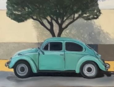 A vintage turquoise Volkswagen Beetle parked beside a tree casting a shadow on a beige wall.