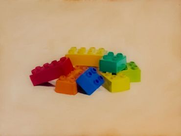 Colorful interlocking toy bricks scattered on a light surface.