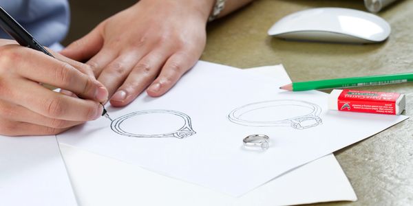 Lady drawing fine jewelry on a white paper with a pencil and rubber. Designs for Ace Fine Jewelry br