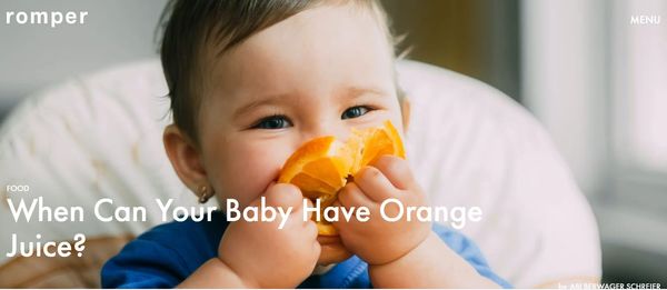 Baby infant eating an orange slice