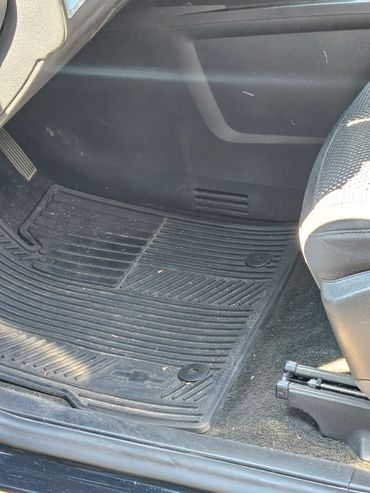 Black rubber floor mat inside a vehicle with Chevrolet logo.