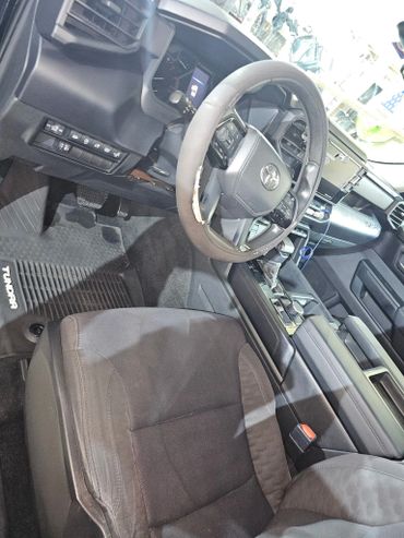 Interior of a Toyota Tundra with a worn steering wheel cover.