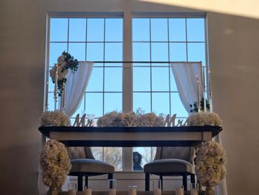 Wedding sweetheart table with floral and candle decorations.