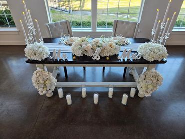 Elegant wedding sweetheart table with white flowers and candles.