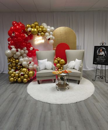 Elegant birthday setup with gold, red, and white balloons.