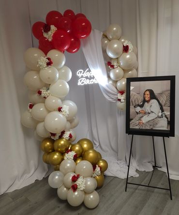 Birthday balloon arch with photo display.