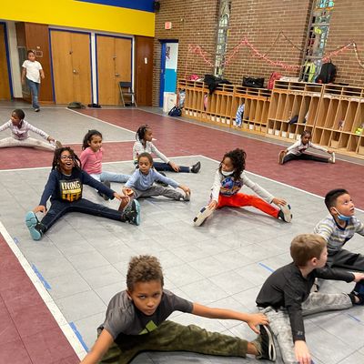 Children stretching in a gym or classroom setting.