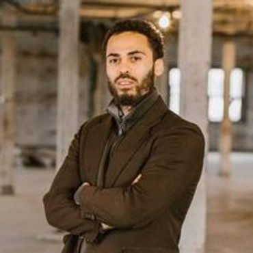 Headshot of a man with arms crossed.