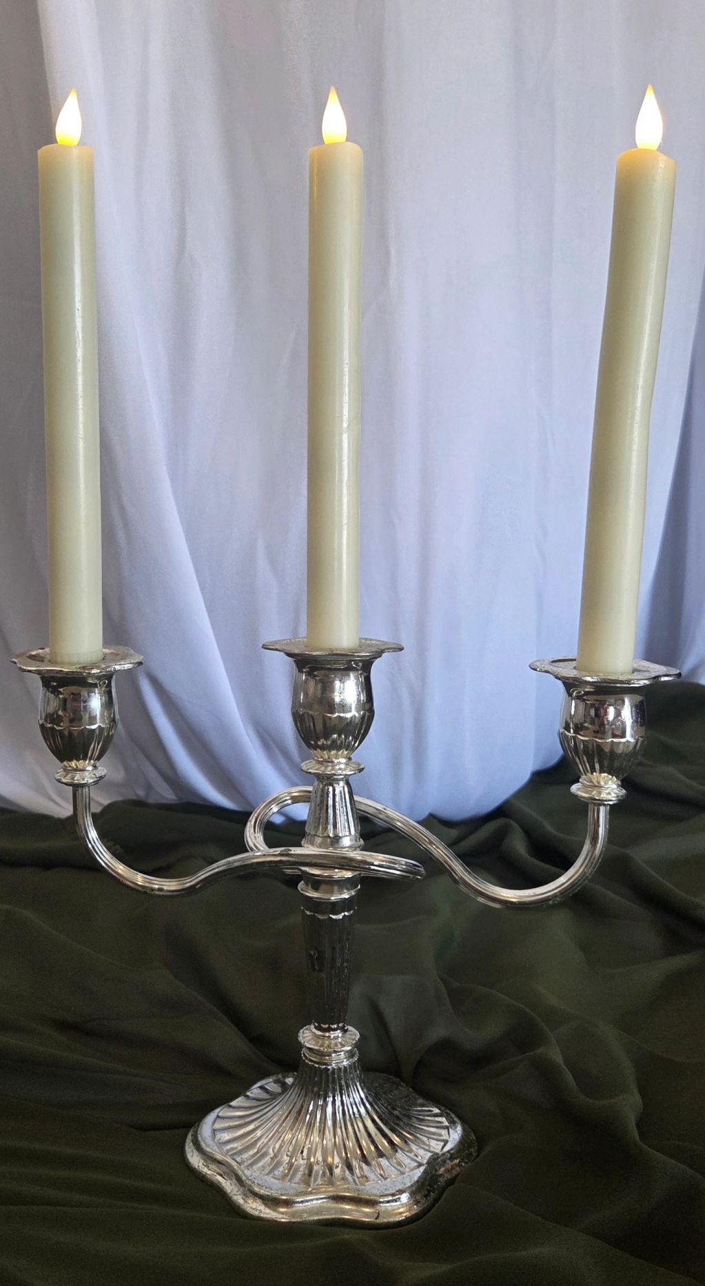 Silver candelabrum with three lit candles.