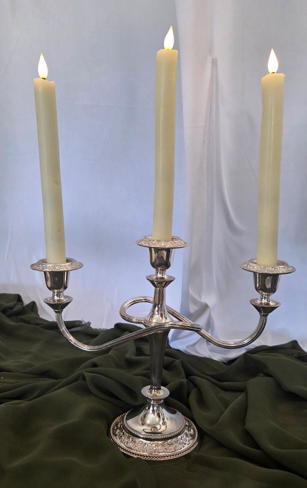 Silver candelabra with three lit candles.