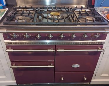 A maroon Lacanche gas stove with multiple burners and ovens.