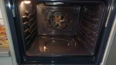 Interior of a clean, empty oven with a star-shaped heating element.