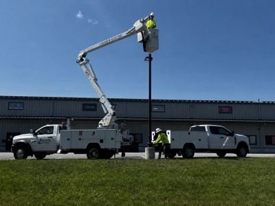 Worker in bucket truck installing a pole.