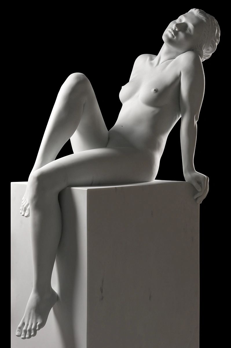 marble sculpture of a naked woman sitting on a marble block created by Marcello Giorgi sculptor.