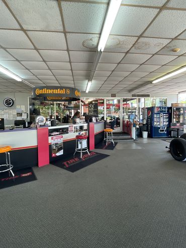 Tire shop interior with service counters, stools, and vending machines.