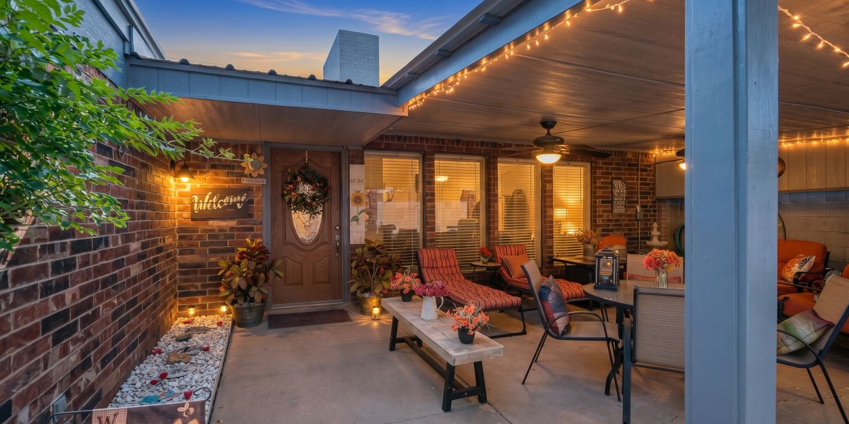 Cozy covered patio with warm lighting and comfortable seating.