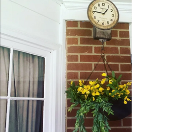 Antique hanging scale with scale holding assorted summer flowers. 