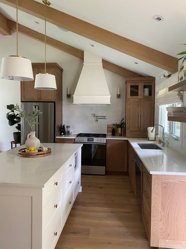 Modern kitchen with wood beams and white countertops.