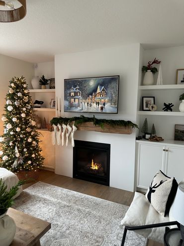 Cozy living room with Christmas tree, stockings, and lit fireplace.