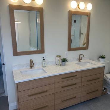 Modern bathroom vanity with dual sinks and wooden cabinetry.