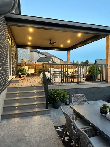 A cozy covered patio with warm lighting and comfortable seating.