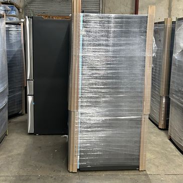 Wrapped refrigerators in a warehouse ready for shipment.