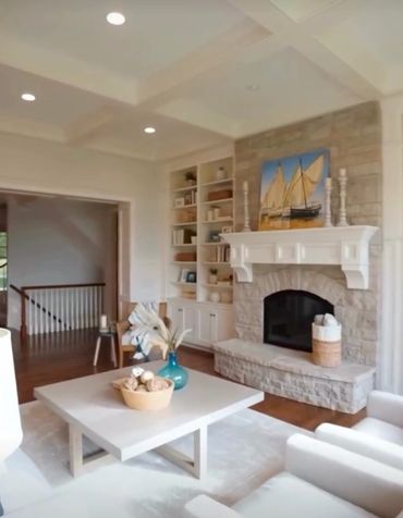 Cozy living room with stone fireplace and sailboat artwork.