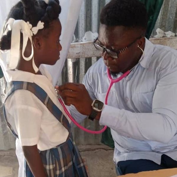Doctor using stethoscope to check girl's heartbeat.