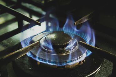 Blue flame burning on a gas stove burner.