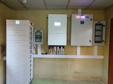 Electrical control panel setup in a room with tiled floor.