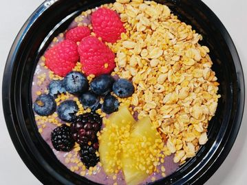 Oatmeal with purple powder and berry toppings 