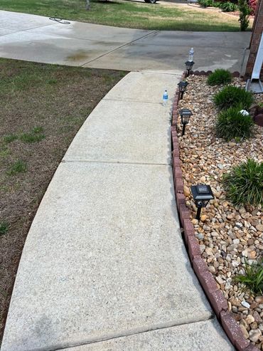 Sidewalk with solar garden lights and two water bottles on the ground.