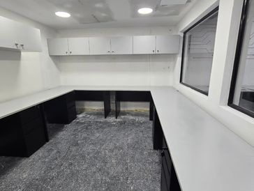 Escritorios secretariales armados en U con pedestal de 3 gavetas y muebles aéreos a la medida.