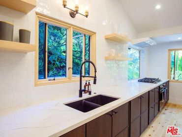 Granite sink basin and custom made pine windows. Custom built floating shelves. 