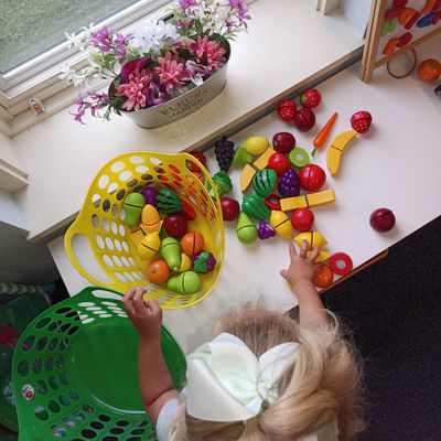 A child engaged in pretend play with play fruit