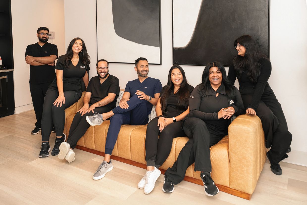 KM Dental Group team of dentists and staff in Etobicoke and Toronto, including Dr. Karnjit Mangat, specialists, and hygienists, photographed inside the clinic.