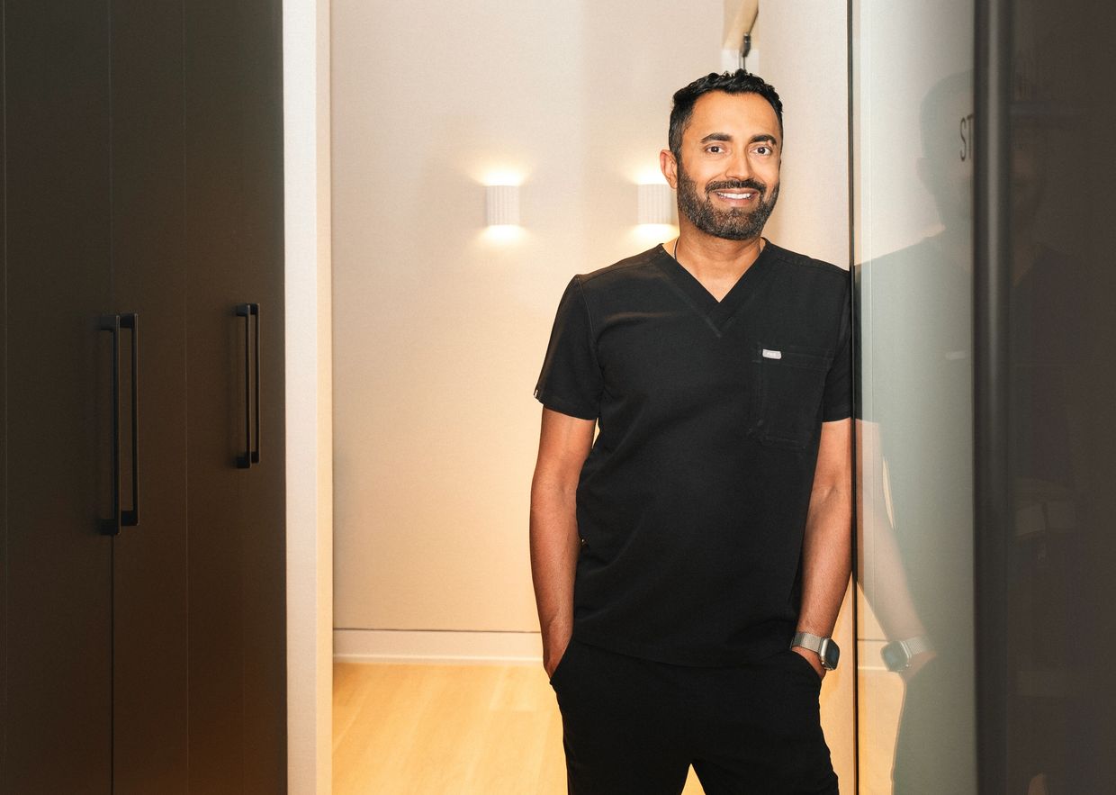Dr. Karnjit Mangat, dentist and Invisalign® provider at KM Dental Group in Etobicoke and Toronto, standing in the clinic hallway.