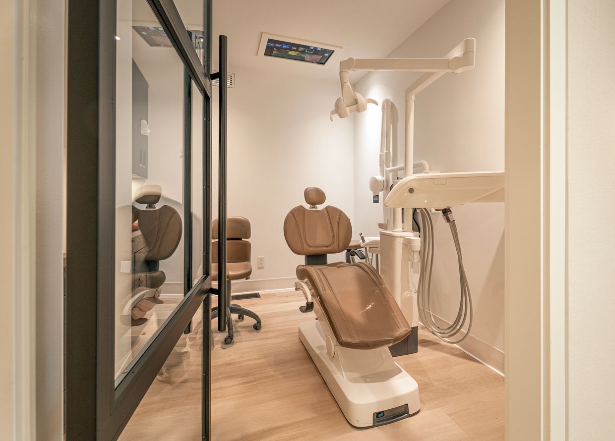 Modern dentist treatment room with chair, digital X-ray, and warm lighting at KM Dental Group