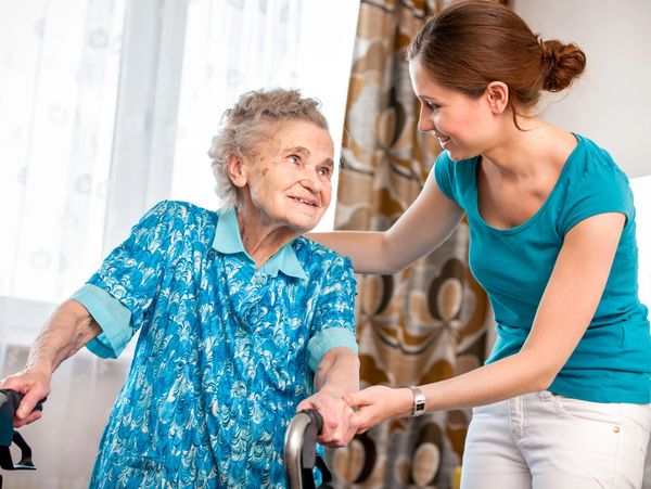 A young woman taking care of an elderly woman at home