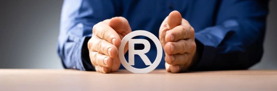 Trademark registration in goa, Man Holding trademark symbol in hand, clover trademark services,