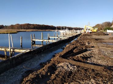 picture of early stage of a marine construction job, readying the site for a new bulkhead by demolit