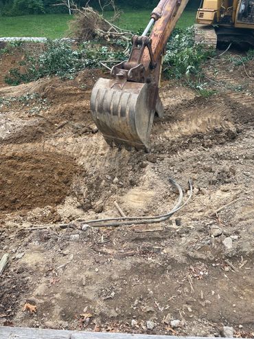 excavator clearing land in a backyard