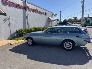 Classic blue vintage station wagon parked outside German Auto World.