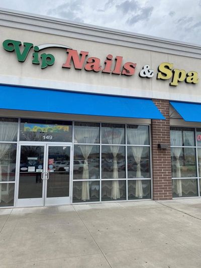 Exterior of Vip Nails & Spa with colorful signage and blue awnings.
