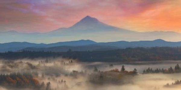 Mount Hood in Oregon with the colors of the sunrise in the background and low fog in the foreground
