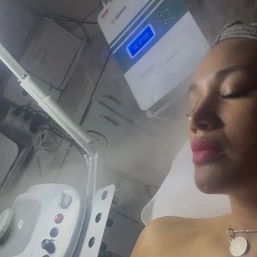 Woman enjoying a facial steam treatment in a spa.
