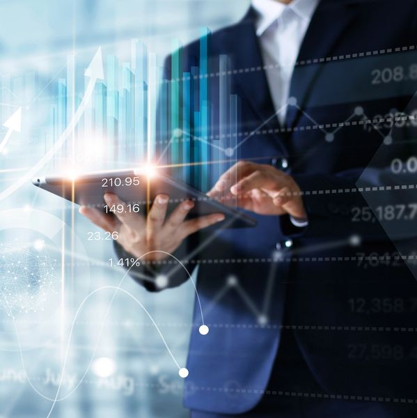 Businessman using tablet analyzing sales data and economic growth graph chart