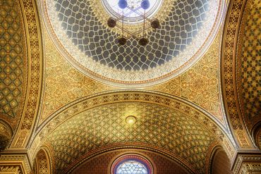 The cupola of Sephardic synagogue in the Moorish style with intricate golden geometric patterns.