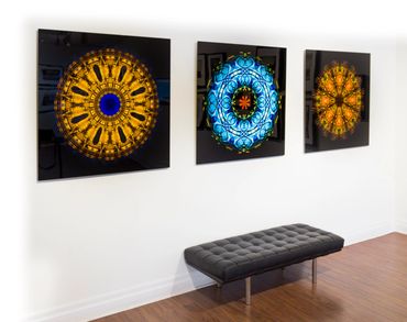Triptych of large iridescent mandalas on black backgrounds in floating frames.