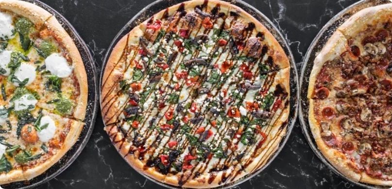 Three pizzas lined up in a row.